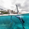 Woman diving half body under water half body above